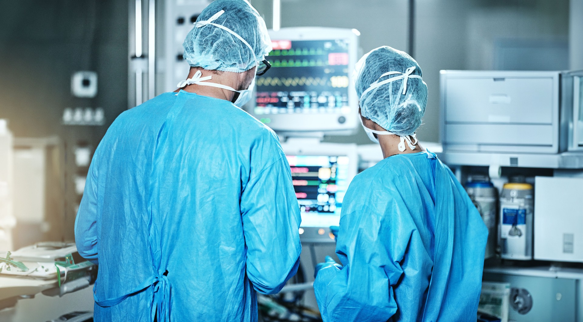 Surgery, back or surgeons with teamwork for emergency, accident or healthcare in hospital clinic. Heart rate monitor, medical or doctors in surgical collaboration in operating room to support or help
